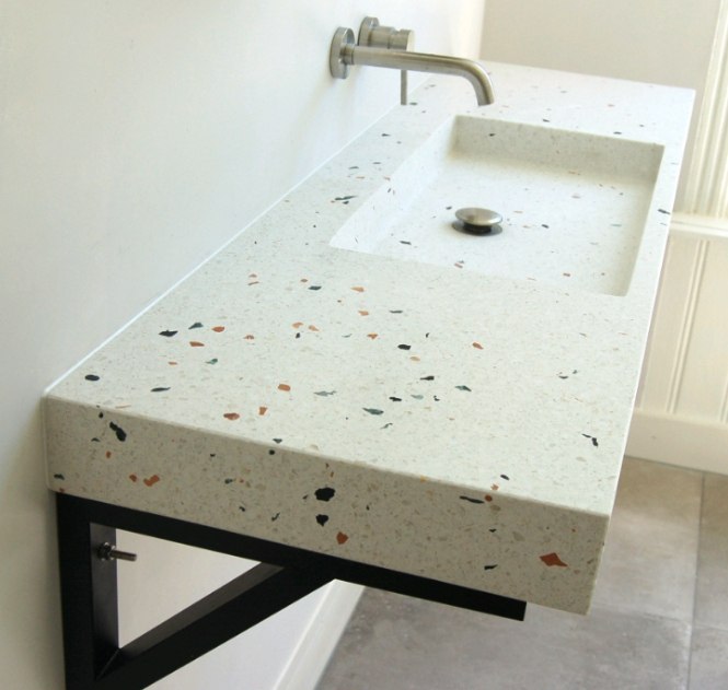 Floating vanity terazzo putih dengan sink rectangular, faucet dinding, dan frame metal hitam